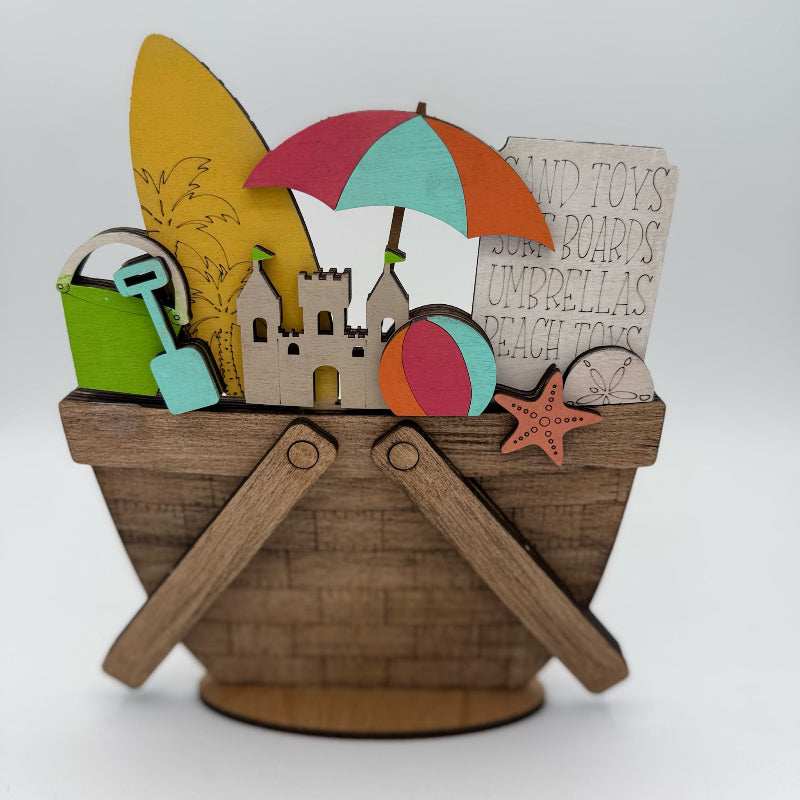 Toy basket with beach-themed items including a castle, umbrella, and ball on a white background