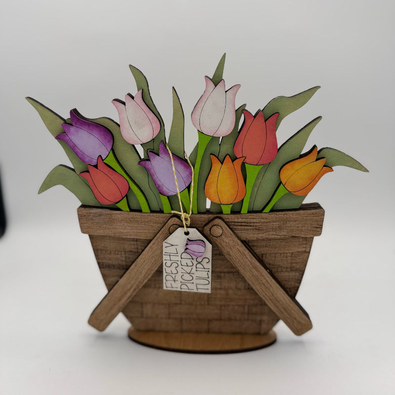 Decorative paper basket with colorful tulips and a tag on a white background