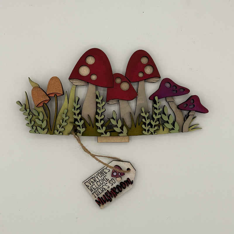 Decorative wall art with red mushrooms and a tag on a white background
