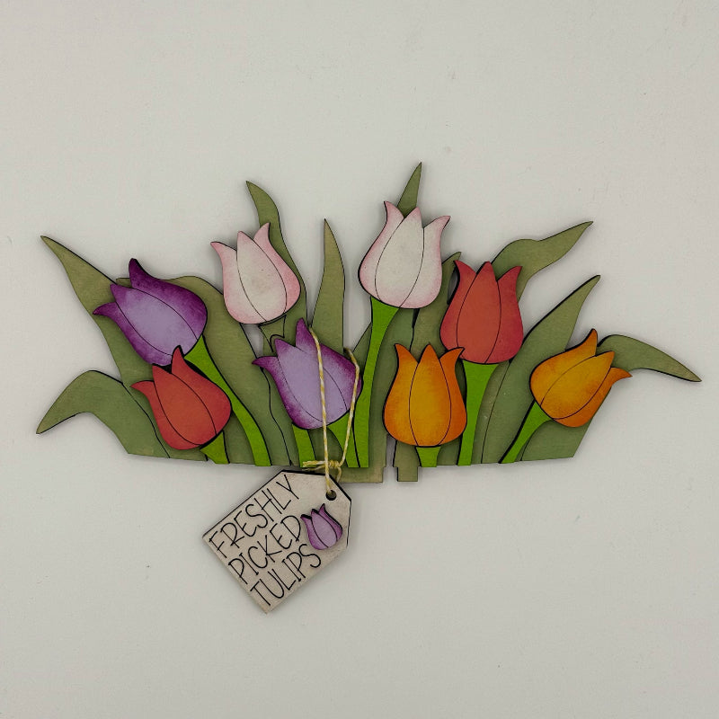 Decorative wall art with colorful tulips and a 'Freshly Picked Tulips' sign on a white background