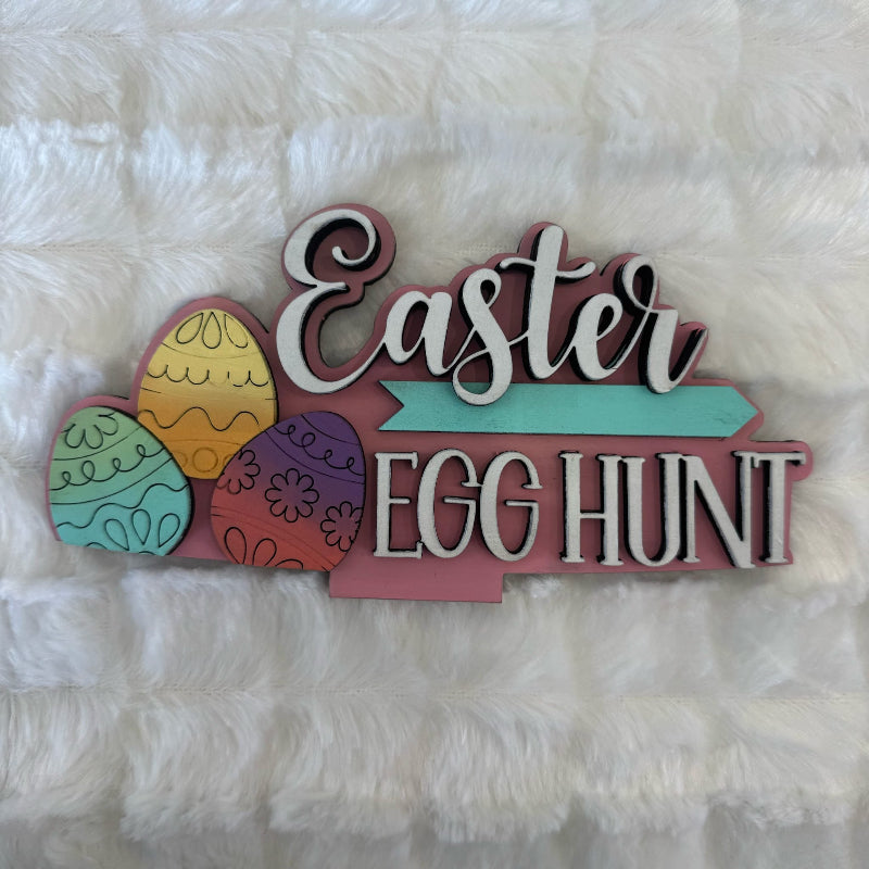 Decorative sign with 'Easter Egg Hunt' text on a fluffy white background