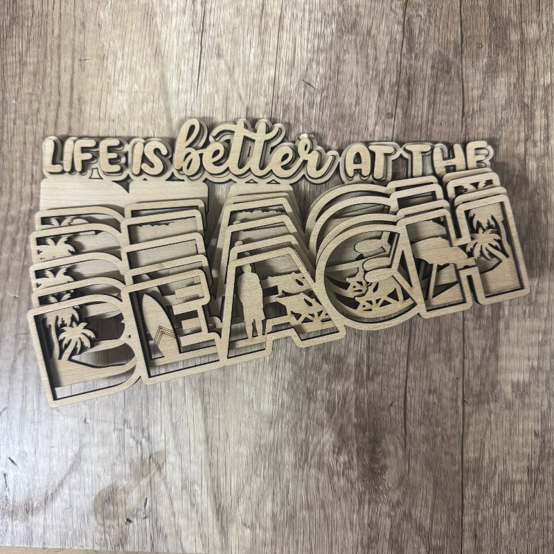 Decorative sign with 'Life is better at the beach' text on a wooden surface