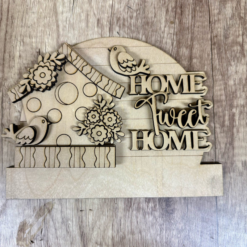 Wooden decorative sign with 'Home Sweet Home' text and birdhouse design on a wooden background