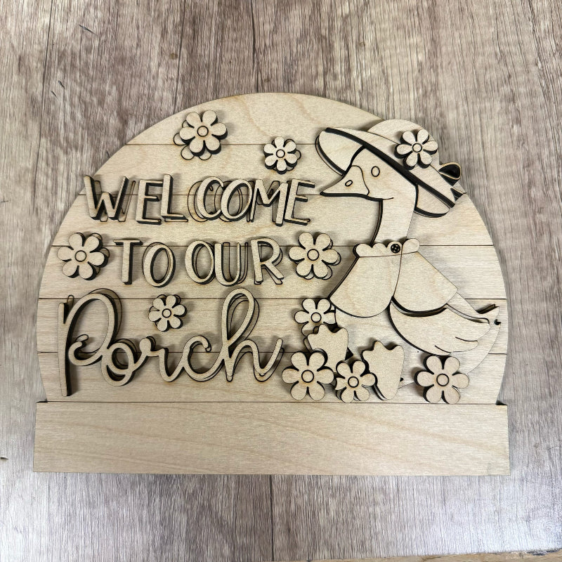 Wooden sign with 'Welcome to our Porch' text and bird design on a wooden background