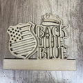 Wooden sign with 'Back the Blue' text and police hat design on a wooden background
