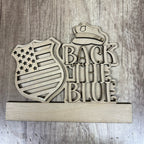 Wooden sign with 'Back the Blue' text and police hat design on a wooden background