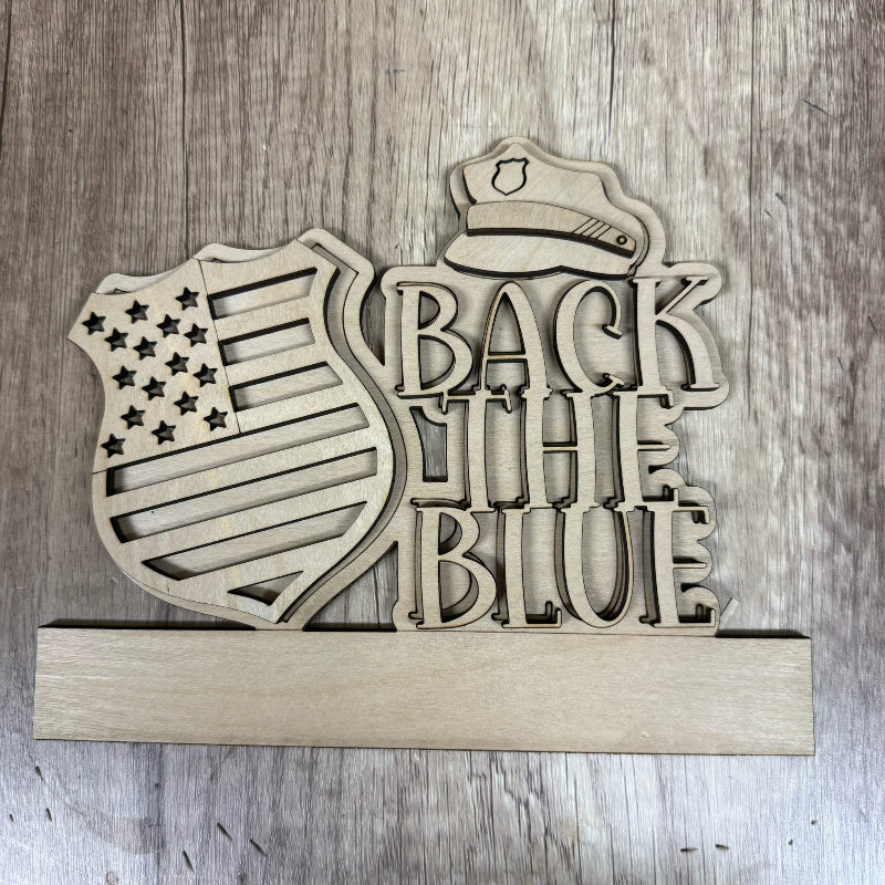 Wooden sign with 'Back the Blue' text and police hat design on a wooden background