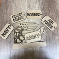 Wooden military-themed decorations including 'Navy', 'Coast Guard', 'Marines', 'Air Force', and 'Army' on a wooden surface.