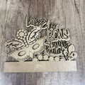 Wooden decorative item with a mask design and French text on a wooden surface
