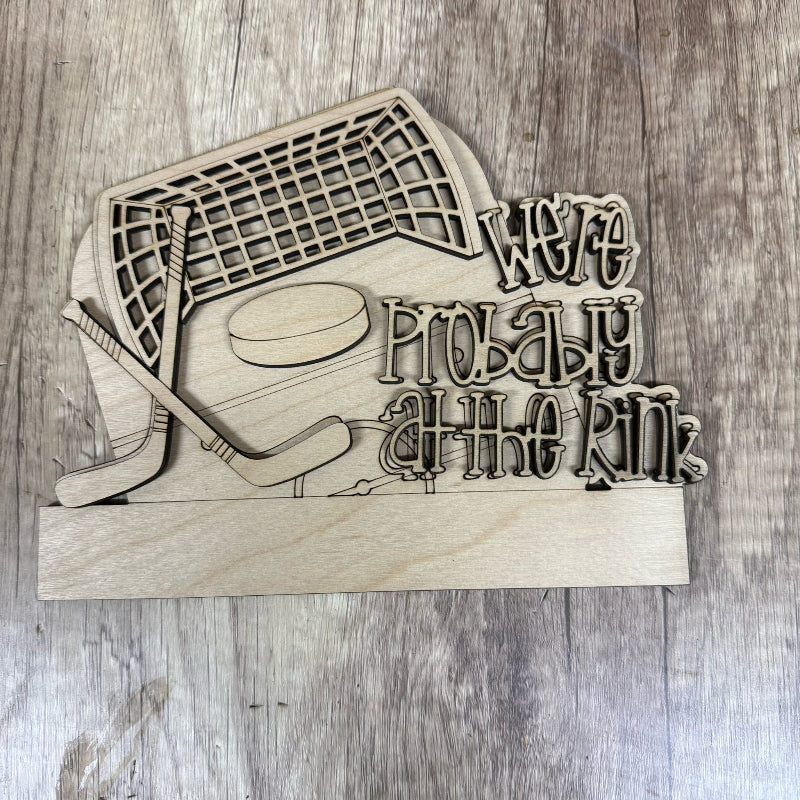 Wooden decorative sign with hockey-themed design and text on a wooden background