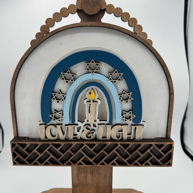 Decorative item with arch, candles, and 'Love & Light' text on a white background