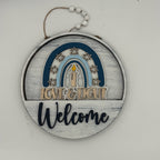 Decorative hanging sign with 'Love & Light Welcome' text on a white background