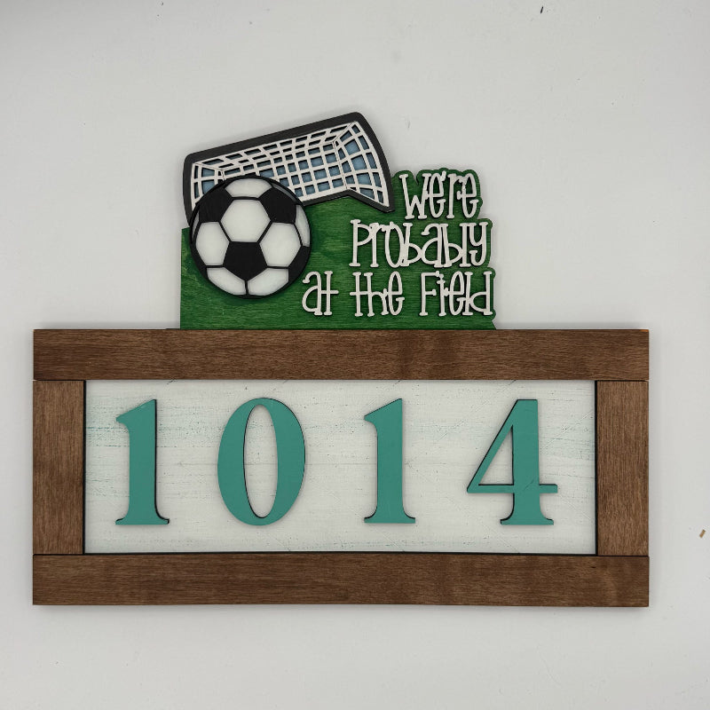 Decorative house number sign with soccer ball and goal on a white background