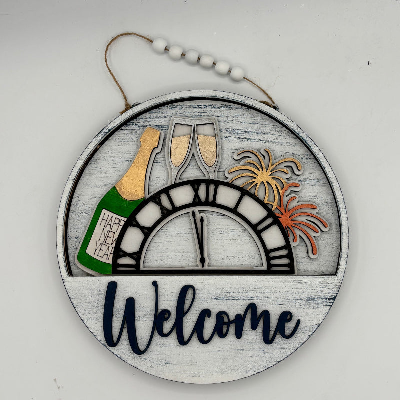 Decorative sign with New Year's Eve elements including a bottle, glasses, and fireworks on a white background.