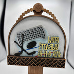 Decorative sign with hockey theme and text 'We're Probably at the Rink' on a stand.
