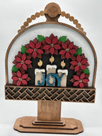 Decorative wooden sign with poinsettias and candles spelling 'JOY' on a white background