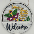 Decorative round sign with Mardi Gras-themed design and 'Welcome' text on a white background.