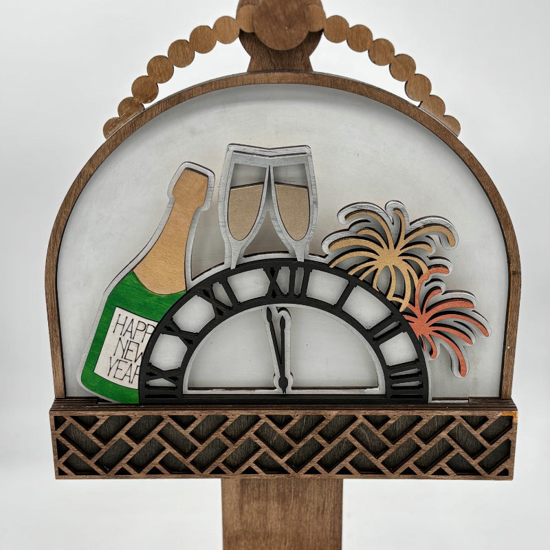 Decorative clock with champagne bottle, glasses, and fireworks design on a white background
