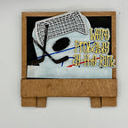 Decorative sign with hockey elements and text 'We're Probably at the Rink' on a white background
