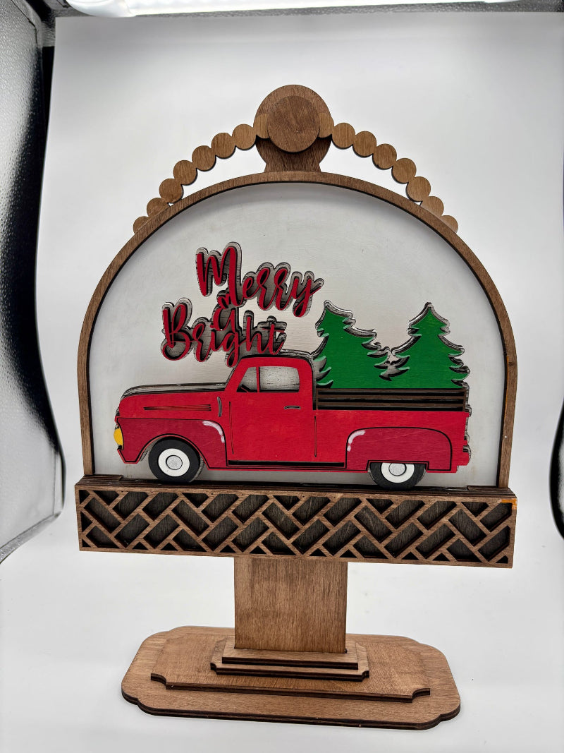 Decorative sign with a red truck and Christmas trees, featuring the text 'Merry Christmas', on a white background.