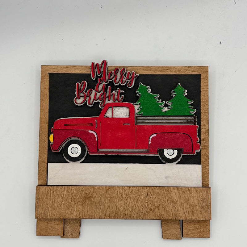 Decorative sign with a red truck and Christmas trees on a black background, featuring the text 'Merry Bright'.