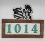 Decorative sign with 'Back the Blue' text, American flag design, and house number '1014'.