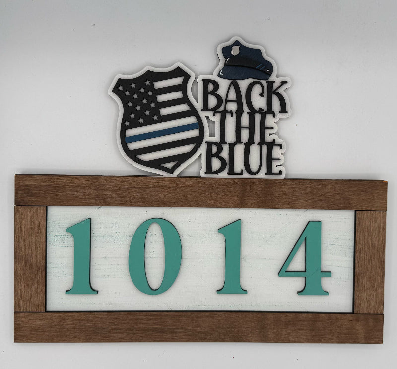 Decorative sign with 'Back the Blue' text, American flag design, and house number '1014'.