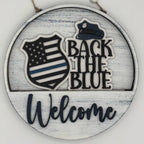 Decorative sign with 'Back the Blue' and 'Welcome' text on a wooden background