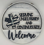 Decorative sign with text 'Serving unselfishly and continuously Welcome' on a white background