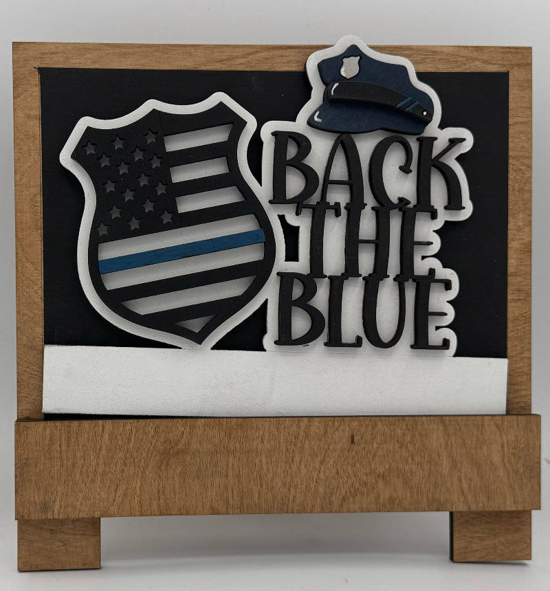 Decorative sign with 'Back the Blue' text and American flag design on a wooden base.