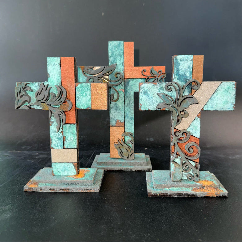 Decorative metal letter 'H' with intricate designs on a dark background