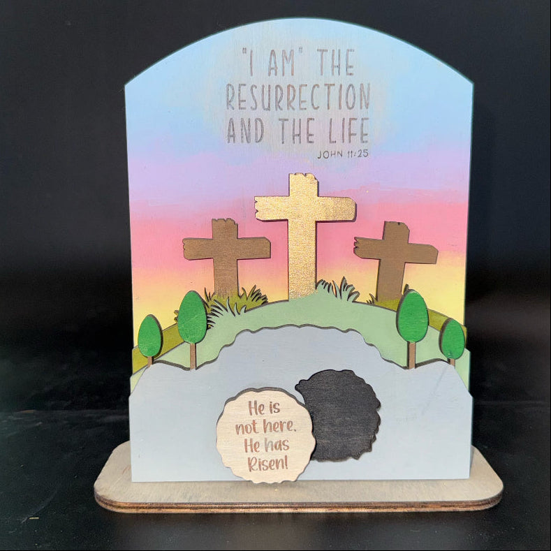 Easter-themed card with crosses and a resurrection message on a stand.