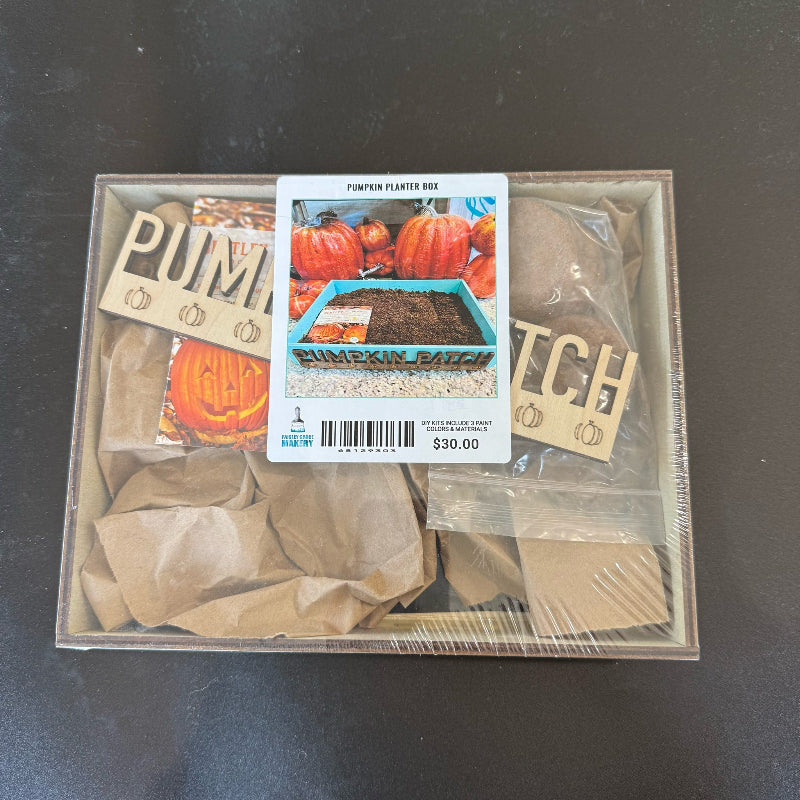 Pumpkin planting kit with decorative signs and packaging on a dark surface