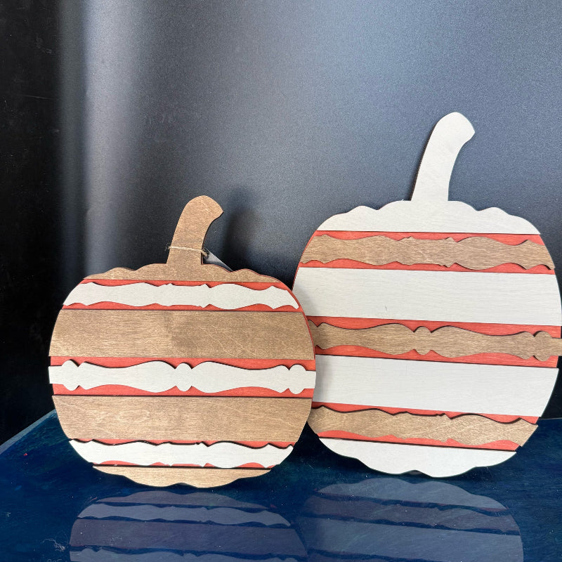 Wooden apple-shaped cutting boards with striped pattern on a dark background