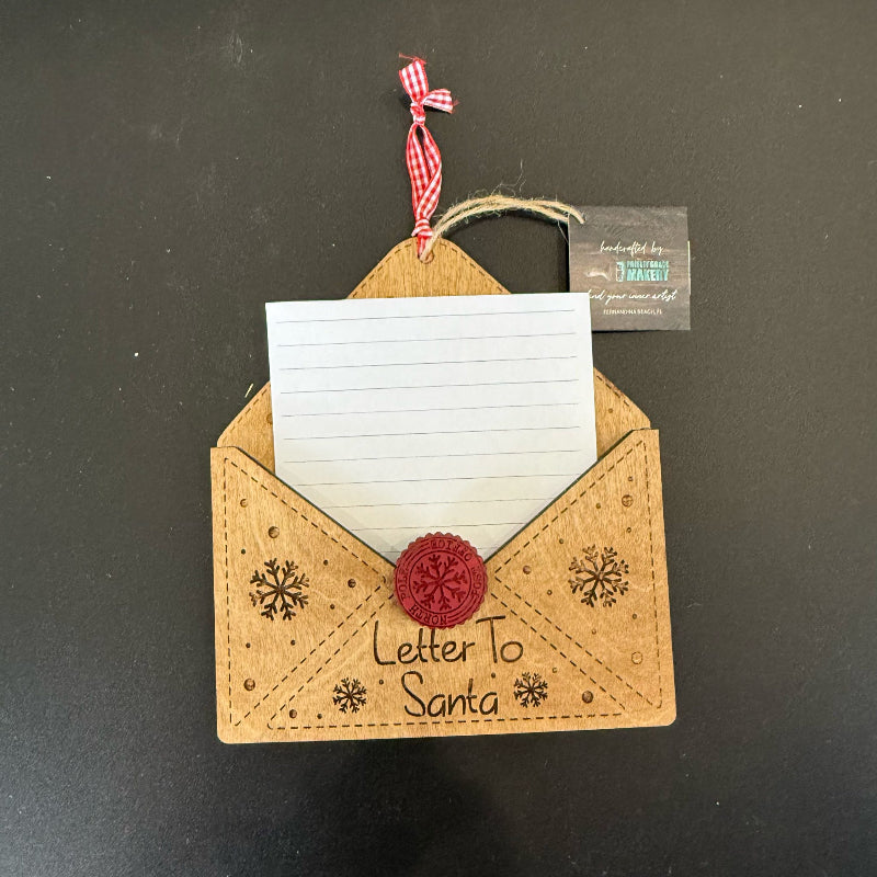 Decorative envelope ornament with a card inside, labeled 'Letter to Santa', on a dark background.