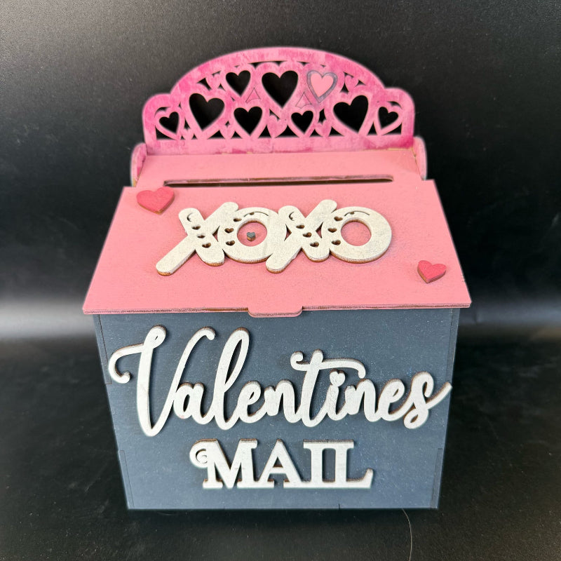 Valentine's Day mailbox with pink top and blue base on a black background