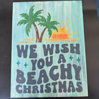 Wooden sign with 'We wish you a beachy Christmas' text and palm tree design on a teal background.
