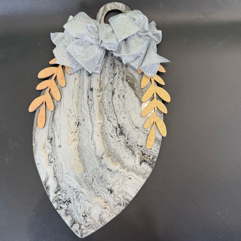 Decorative wall piece with marble pattern and leaf designs on a dark background