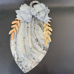 Decorative wall piece with marble pattern and leaf designs on a dark background