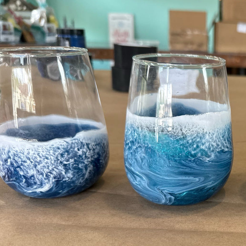 Four blue and white patterned glasses on a wooden surface with a blurred background.