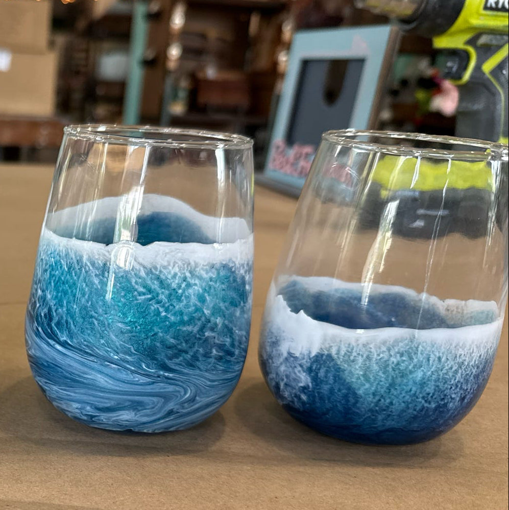 Four blue and white patterned glasses on a wooden surface with a blurred background.