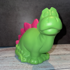 Unpainted ceramic dinosaur figurine on a wooden surface with a dark background