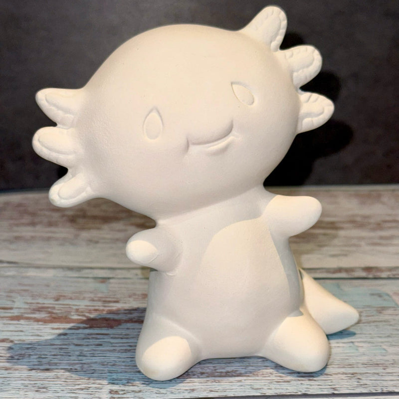 White ceramic sun-shaped object on a wooden surface with a dark background
