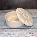 White ceramic dish with lid on a wooden surface