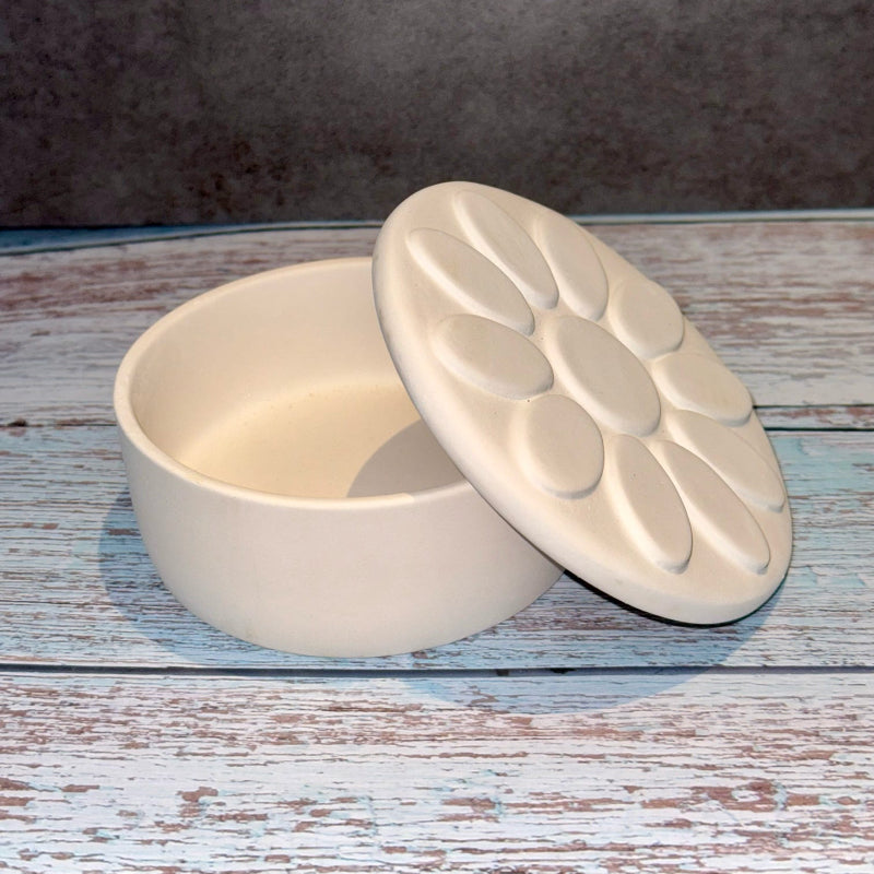 White ceramic dish with lid on a wooden surface