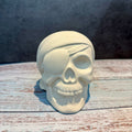 Skull-shaped object with a bandage on a wooden surface