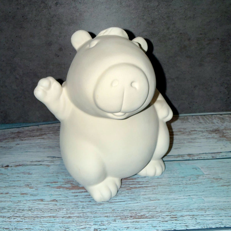 White ceramic bear figurine on a textured blue surface with a gray background