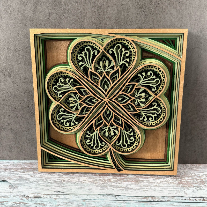 Decorative four-leaf clover design in a wooden frame on a gray background