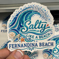 Sticker with 'Salty Like a Beach Fernandina Beach' design held by a hand.