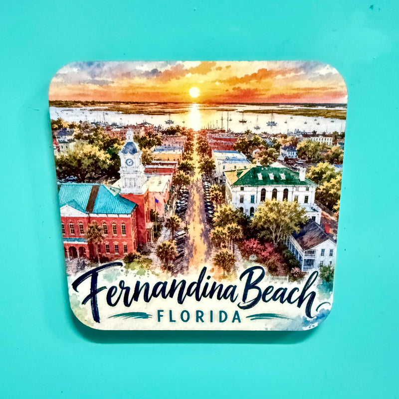 A square coaster with rounded corners featuring a colorful watercolor illustration of Fernandina Beach, Florida, with the text 'Fernandina Beach FLORIDA' at the bottom, shown on a solid turquoise background.